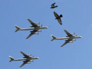 FILE - A trio of Tu-95 nuclear-capable strategic bombers of the Russian air force fly over Pushkin Square in Moscow, Russia, on May 3, 2014 during a rehearsal for the Victory Day military parade which will take place at Moscow&rsquo;s Red Square on May 9 to celebrate 69 years of the victory in WWII.