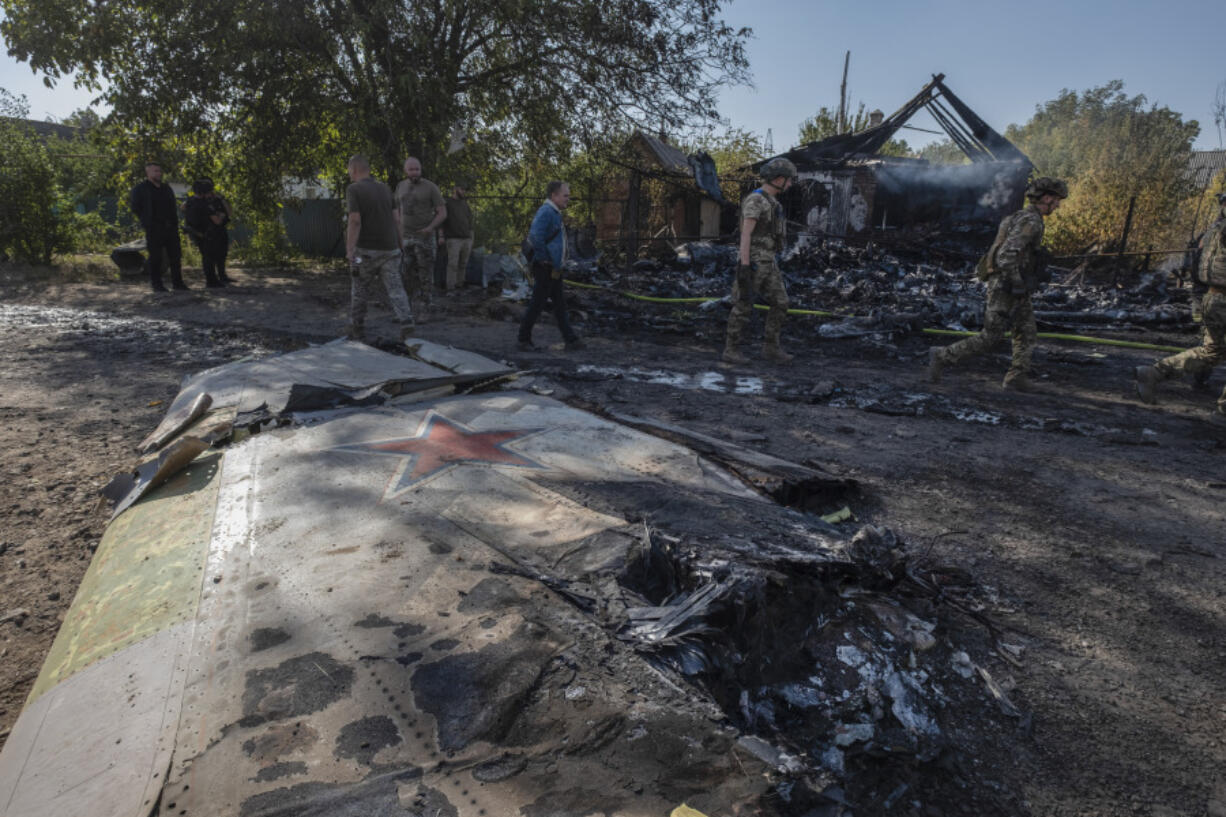 Ukrainian servicemen examine fragments of a Russian military plane that was shot down, on the outskirts of Kostyantynivka, a near-front line city in the Donetsk region, Ukraine, Saturday, Oct. 5, 2024.