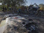 Ukrainian servicemen examine fragments of a Russian military plane that was shot down, on the outskirts of Kostyantynivka, a near-front line city in the Donetsk region, Ukraine, Saturday, Oct. 5, 2024.