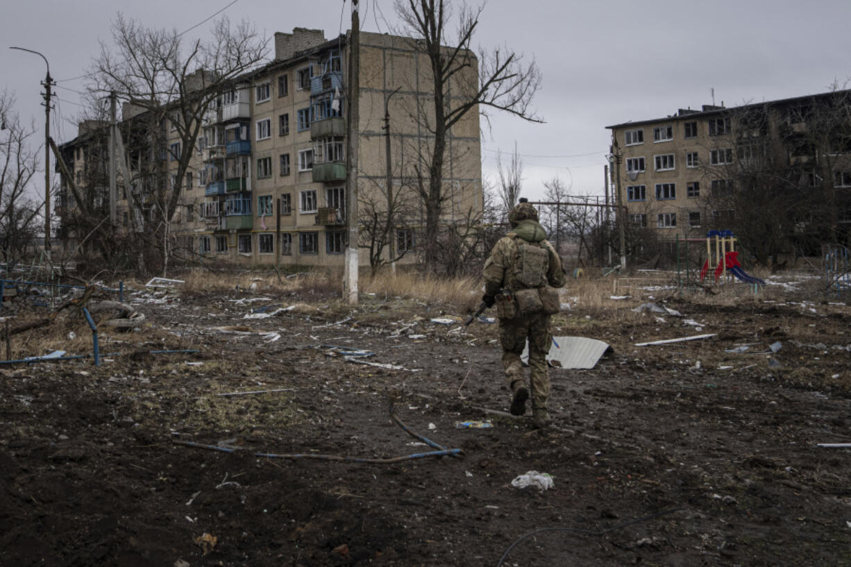 FILE - A Ukrainian marine serviceman runs to take a position through the residential blocks in the frontline city of Vuhledar, Ukraine, Feb. 25, 2023.