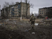 FILE - A Ukrainian marine serviceman runs to take a position through the residential blocks in the frontline city of Vuhledar, Ukraine, Feb. 25, 2023.