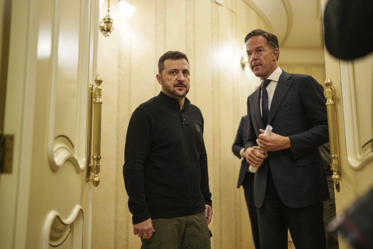 NATO Secretary General Mark Rutte, left, and Ukrainian President Volodymyr Zelenskyy speak in a corridor ahead of a press conference in Kyiv, Ukraine, Thursday Oct. 3, 2024.