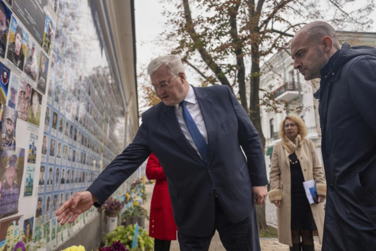 Minister of Foreign Affairs Andrii Sybiha speaks to French Foreign Minister Jean-Noel Barrot about one of the fallen soldier at the memorial for Ukrainian killed soldiers in central Kyiv, Ukraine, Saturday, Oct. 19, 2024.