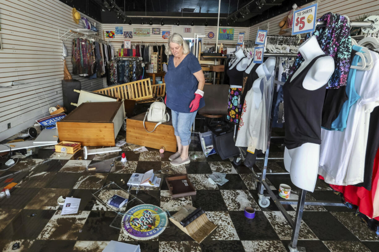 FILE - Jill Rice looks over the damage to her store caused by flooding from Hurricane Helene, Sept. 27, 2024, in Gulfport, Fla.