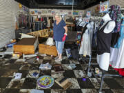 FILE - Jill Rice looks over the damage to her store caused by flooding from Hurricane Helene, Sept. 27, 2024, in Gulfport, Fla.