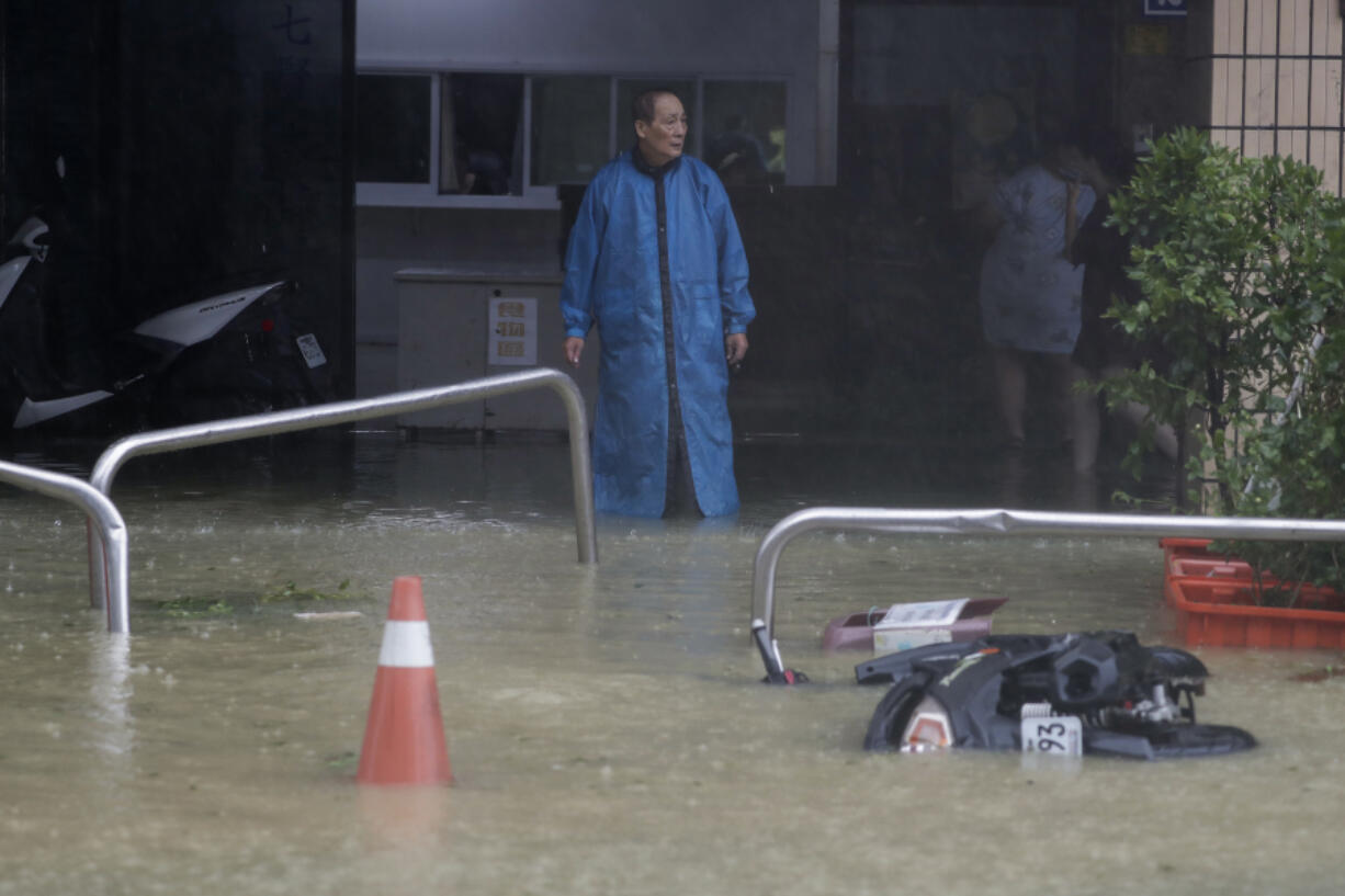 A man looks at a flooded road as Typhoon Krathon makes landfall in Kaohsiung, southern Taiwan, Thursday, Oct. 3, 2024.