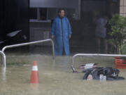 A man looks at a flooded road as Typhoon Krathon makes landfall in Kaohsiung, southern Taiwan, Thursday, Oct. 3, 2024.