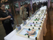 Relatives of the bus fire victims view their portraits at the Wat Khao Phraya Sangkharam School Lan Sak, Uthai Thani province, Thailand, Wednesday, Oct. 2, 2024.