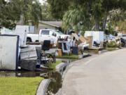 Residents discard items from their homes which filled with floodwaters from Hurricane Helene in the Shore Acres neighborhood on Saturday, Sept. 28, 2024, in St. Petersburg, Fla.