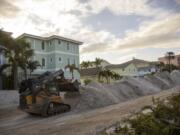 Crews work to clean up the tons of sand and debris pushed onto Gulf Boulevard from Hurricane Helene storm surge, Saturday, Sept. 28, 2024, in Indian Shores, Fla.