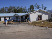 A group from St. Augustine, Fla., who did not want to give their name, that came to help storm victims, arrive to pray outside the damaged First Baptist Church in the aftermath of Hurricane Helene, in Horseshoe Beach, Fla., Sunday, Sept. 29, 2024.