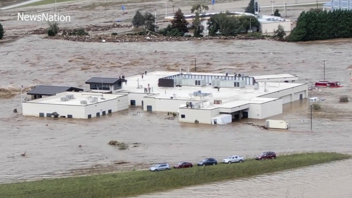 In this image made from a video provided by NewsNation, people can be seen on the roof of the Unicoi County Hospital in Erwin, Tenn., on Friday, Sept. 27, 2024.