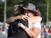 FILE - People hug after Republican presidential candidate former President Donald Trump was helped off the stage at a campaign event in Butler, Pa., July 13, 2024. (AP Photo/Gene J.