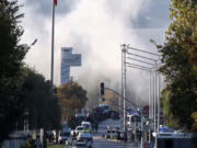 Smoke raises as emergency rescue teams and police officers attend outside Turkish Aerospace Industries Inc. on the outskirts of Ankara, Turkey, Wednesday, Oct. 23, 2024.