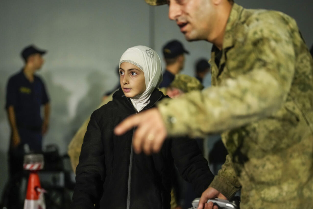 People, mostly Turkish nationals, disembark from Turkish TCG Sancaktar military ship after being evacuated from Lebanon&rsquo;s capital Beirut to Turkey, in Mersin port, southern Turkey, early Friday, Oct. 11, 2024.