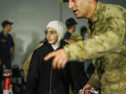 People, mostly Turkish nationals, disembark from Turkish TCG Sancaktar military ship after being evacuated from Lebanon&rsquo;s capital Beirut to Turkey, in Mersin port, southern Turkey, early Friday, Oct. 11, 2024.