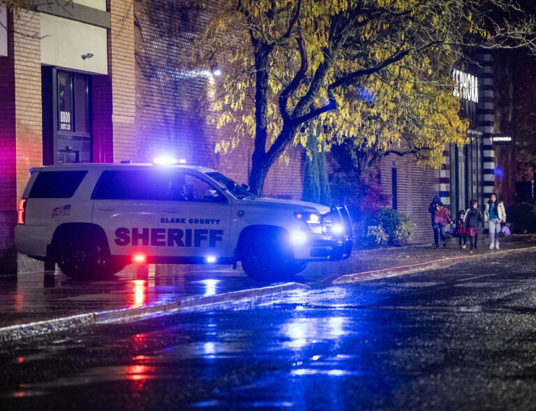 People walk along the sidewalk outside of the Vancouver Mall on Thursday, Oct. 31, 2024, after a shooting.