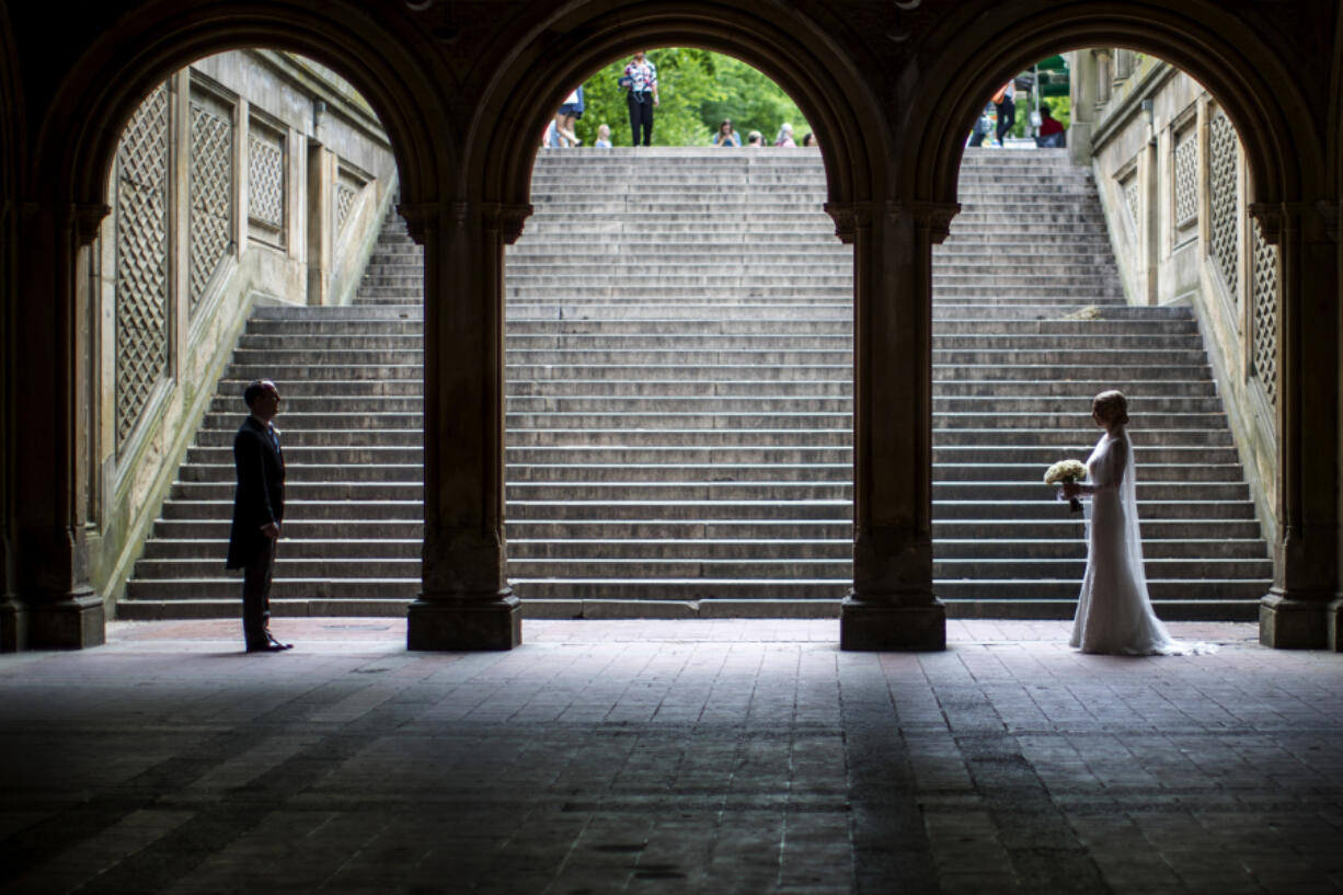 FILE - A bride and groom pose for wedding pictures at the Bethesda Terrace in New York&rsquo;s Central Park on May 23, 2017.