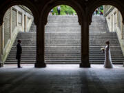 FILE - A bride and groom pose for wedding pictures at the Bethesda Terrace in New York&rsquo;s Central Park on May 23, 2017.