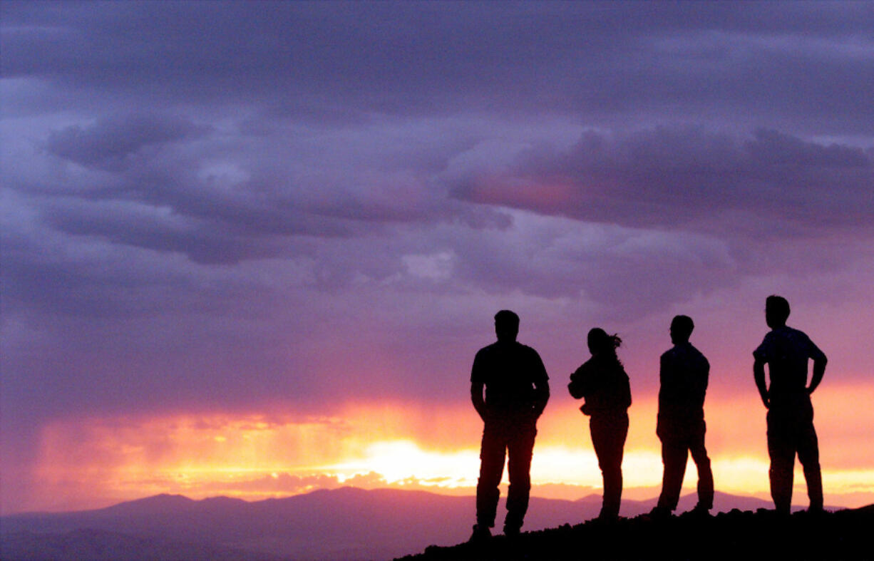 People watch the setting sun illuminate a thunder storm July 20, 1999, atop Rattlesnake Mountain near Richland (AP Photo/Tri-City Herald, Chris Thelen)