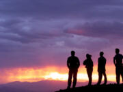 People watch the setting sun illuminate a thunder storm July 20, 1999, atop Rattlesnake Mountain near Richland (AP Photo/Tri-City Herald, Chris Thelen)