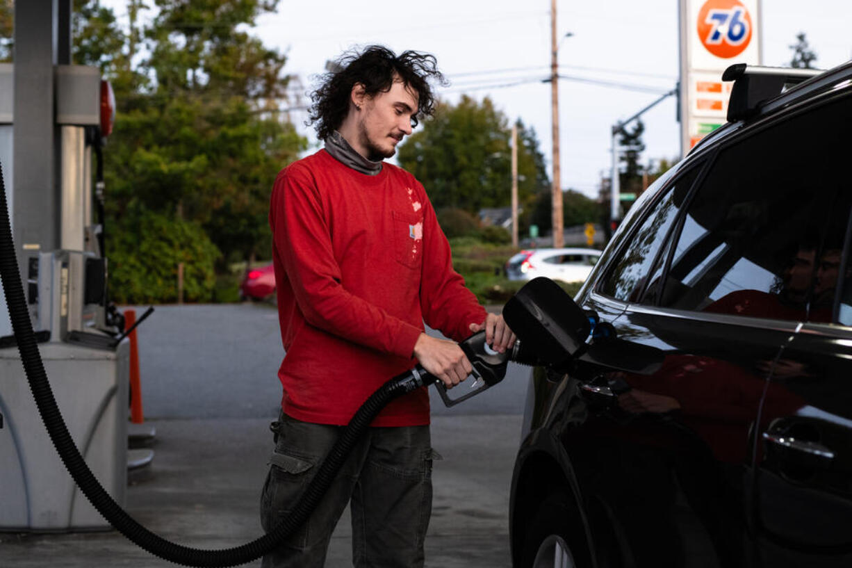 Brandon Borg, 21, fills up his car with gas in Everett, Oct. 24, 2024. Borg must drive long distances for work and is worried about how the rise in gas prices will affect his ability to save money for his future.