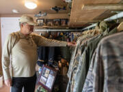 Thomas Renner Sr., 72, flips through his collection of military uniforms at his home in Woodland. At 18, he volunteered to fight in the Vietnam War. He has 32 family members who have served, including his son, Josiah Renner.  At top, Thomas Renner Sr., right, during the Vietnam War.