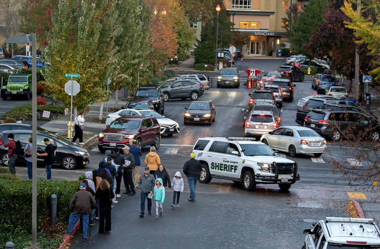 Law enforcement officers are seen as people wait to register to vote, left, and drop off their ballots at the downtown Vancouver elections office Monday evening, Nov. 4, 2024.