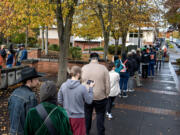 A long line of voters reaches the courtyard of the public service center as people wait to vote in person at the elections office in downtown Vancouver on Tuesday afternoon, Nov. 5, 2024.