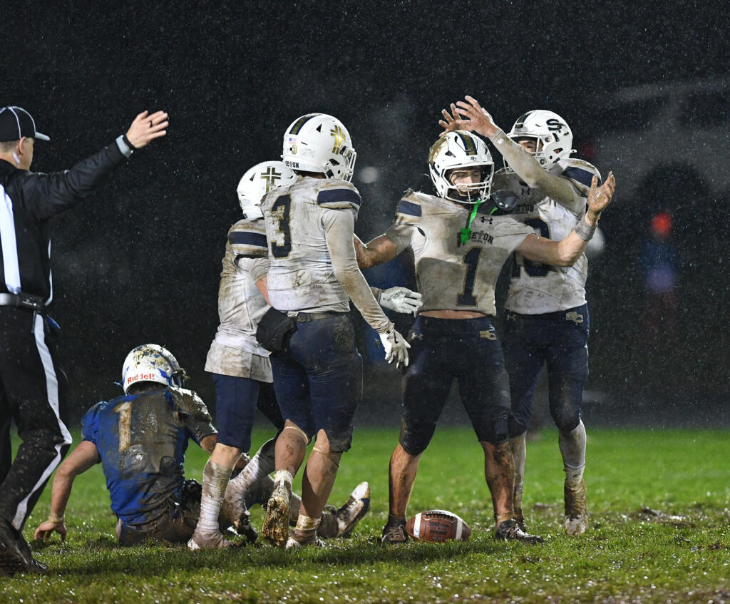 Seton Catholic senior Joe Callerame (1) is crowned by  senior Lukas Morse, right, after Callerame made a game-sealing interception Friday, Nov. 1, 2024, during Seton Catholic’s 29-21 win against La Center at La Center High School. Seton won the 1A Trico League Championship with the victory.