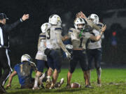 Seton Catholic senior Joe Callerame (1) is crowned by  senior Lukas Morse, right, after Callerame made a game-sealing interception Friday, Nov. 1, 2024, during Seton Catholic’s 29-21 win against La Center at La Center High School. Seton won the 1A Trico League Championship with the victory.