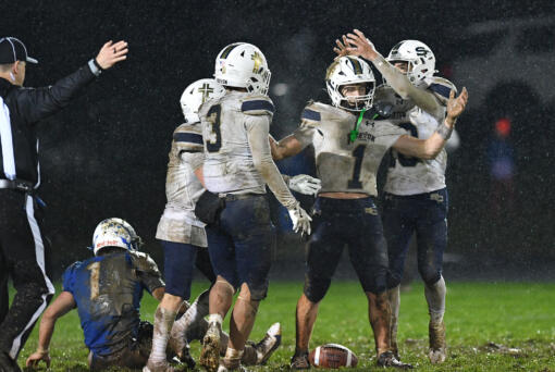 Seton Catholic senior Joe Callerame (1) is crowned by  senior Lukas Morse, right, after Callerame made a game-sealing interception Friday, Nov. 1, 2024, during Seton Catholic’s 29-21 win against La Center at La Center High School. Seton won the 1A Trico League Championship with the victory.