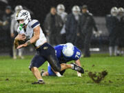 Seton Catholic senior Joe Callerame, left, slips on the grass Friday, Nov. 1, 2024, during Seton Catholic’s 29-21 win against La Center at La Center High School. Seton won the 1A Trico League Championship with the victory.