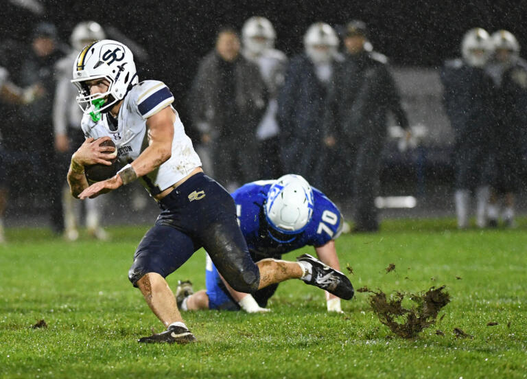 Seton Catholic senior Joe Callerame, left, slips on the grass Friday, Nov. 1, 2024, during Seton Catholic’s 29-21 win against La Center at La Center High School. Seton won the 1A Trico League Championship with the victory.