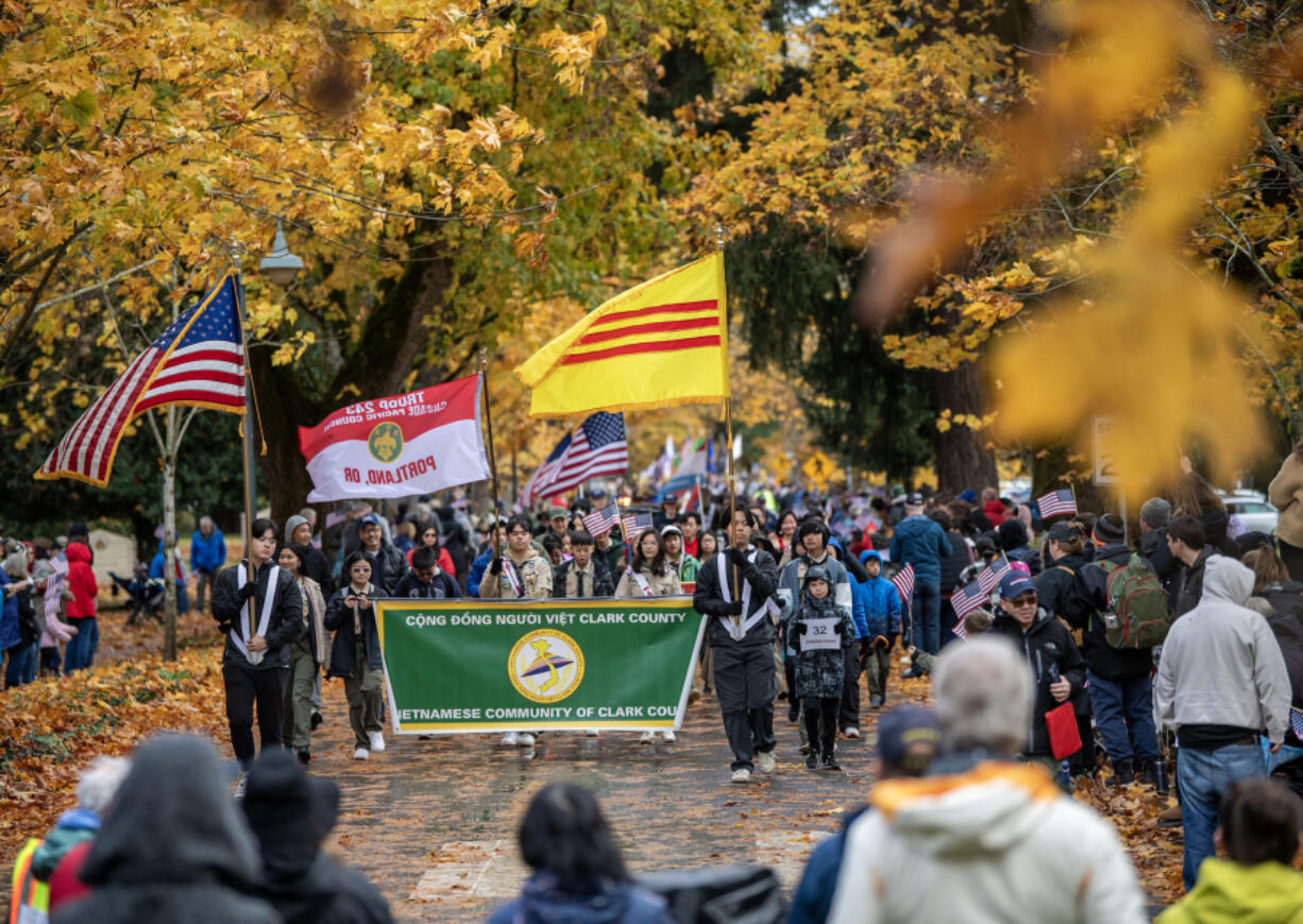 Vietnamese Community of Clark County members hold flags and march Monday during the 36th Annual Lough Legacy Veterans Parade at Fort Vancouver National Historic Site.