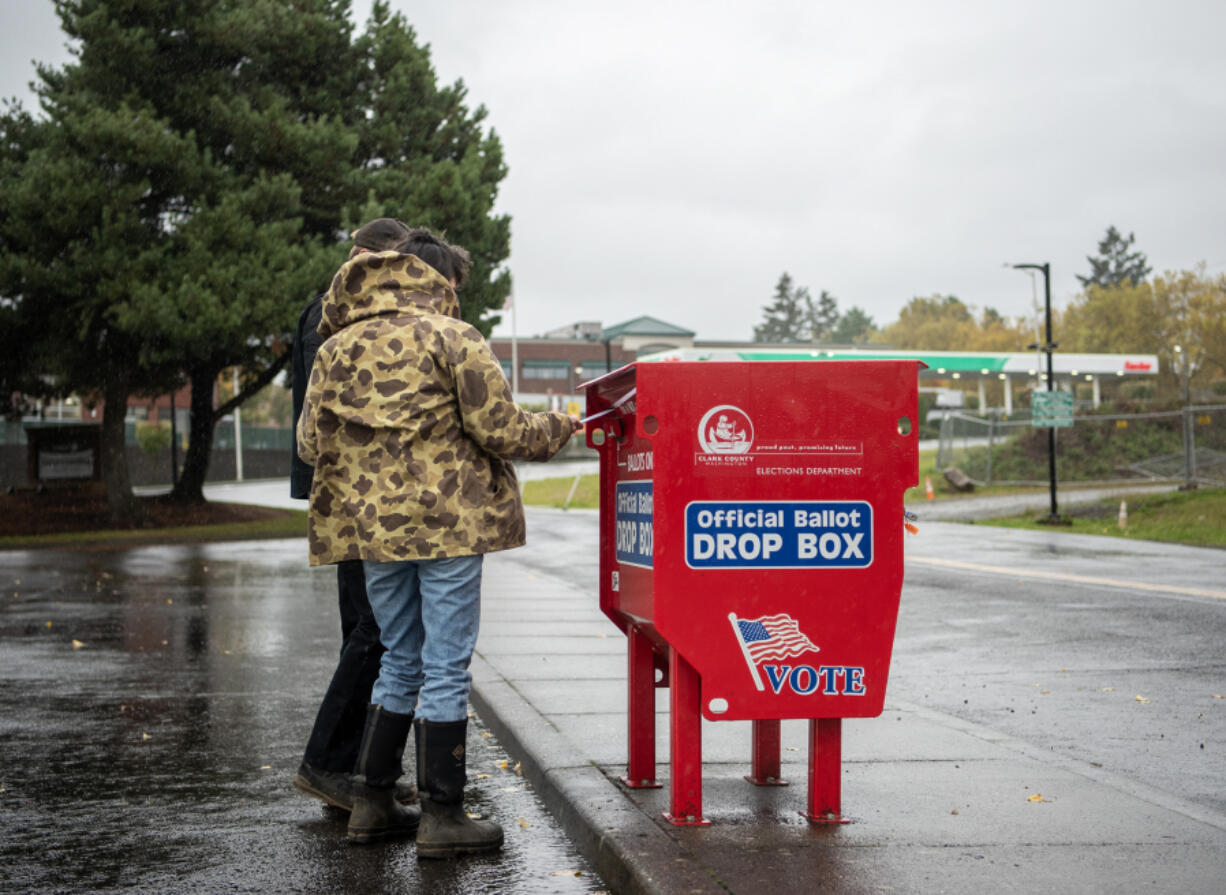 U.S. Rep. Marie Gluesenkamp Perez, D-Skamania, foreground, and her husband Dean Gluesenkamp cast their ballots at the Fisher&rsquo;s Landing ballot drop box on Friday. The box was the site of arson on Monday that damaged almost 500 ballots.