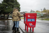 U.S. Rep. Marie Gluesenkamp Perez, D-Skamania, foreground, and her husband Dean Gluesenkamp cast their ballots at the Fisher&rsquo;s Landing ballot drop box on Friday. The box was the site of arson on Monday that damaged almost 500 ballots.