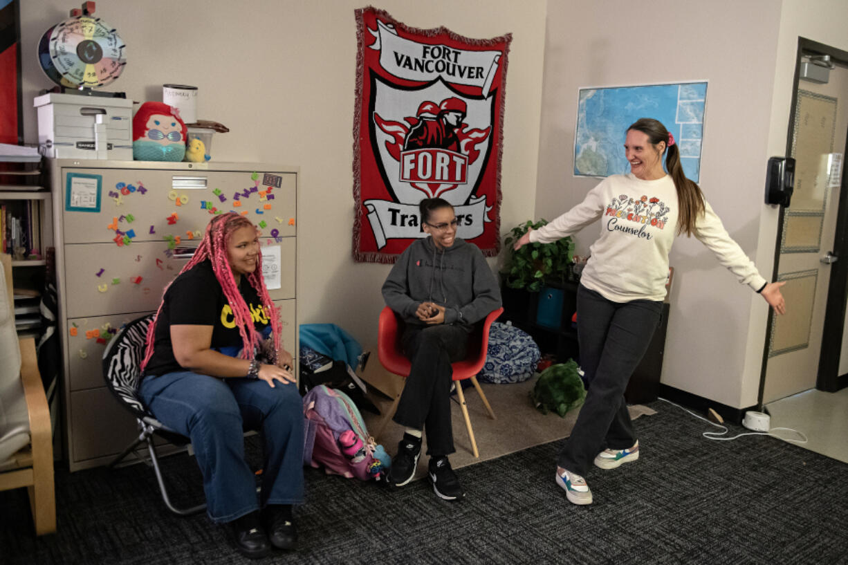 LEADOPTION Great Prevention Club members senior Zamyrah Scott, 17, left, and junior Emaunie Bush, 16, look on as prevention counselor Alizz Quarles shows off her sweatshirt during a meeting at Fort Vancouver High School.