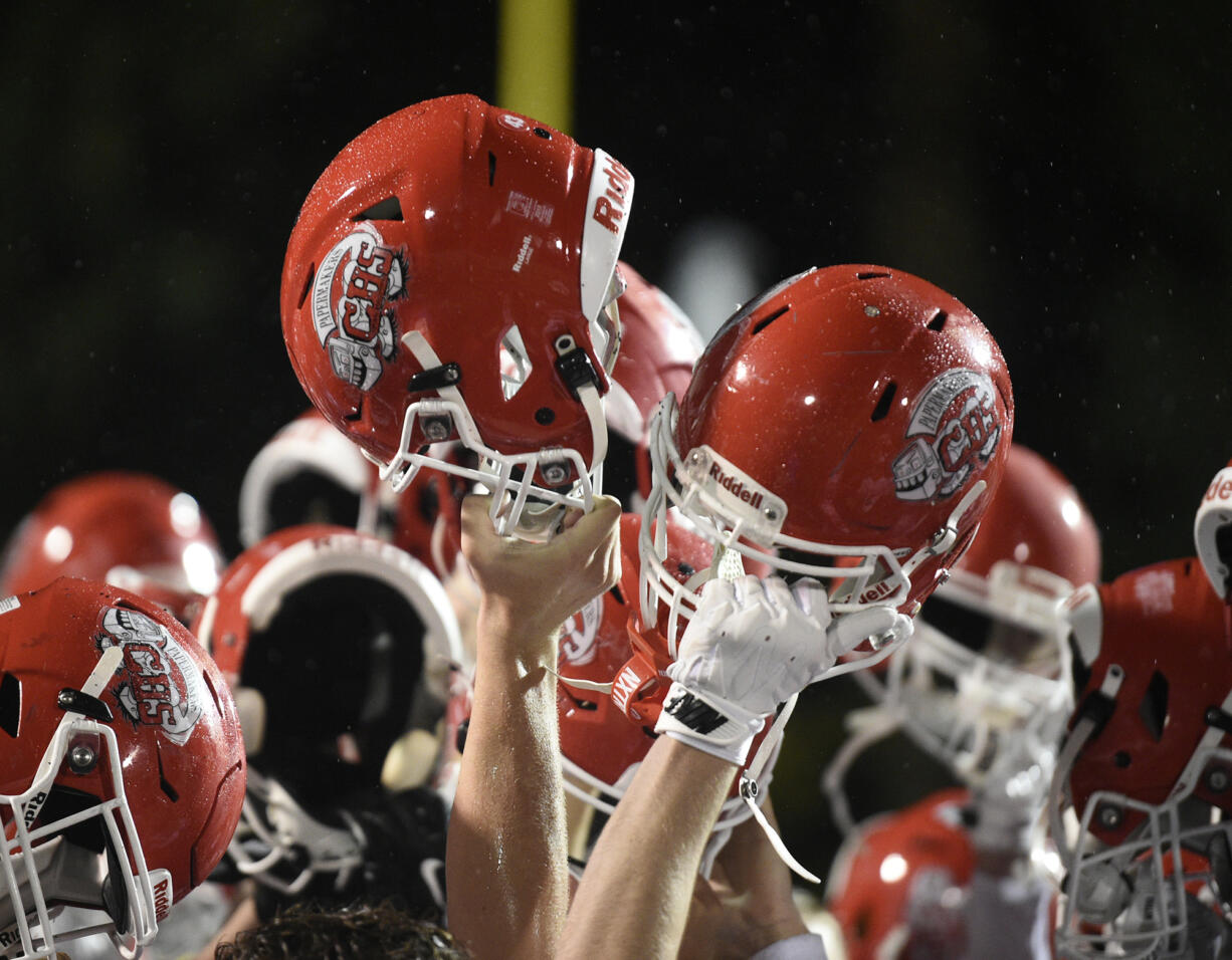 Camas players hold up their helmets after beating Skyview in a 4A Greater St. Helens League football game at Kiggins Bowl on Friday, Nov. 1, 2024.