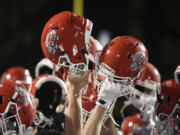 Camas players hold up their helmets after beating Skyview in a 4A Greater St. Helens League football game at Kiggins Bowl on Friday, Nov. 1, 2024.