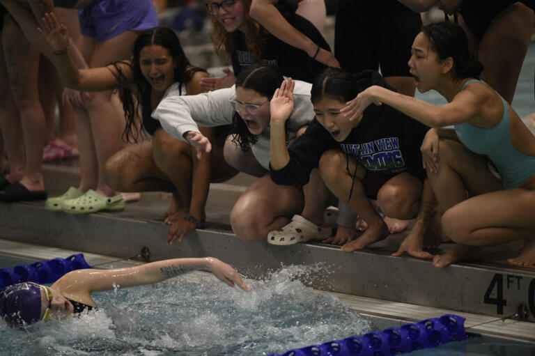 Members of the Evergreen Public Schools swim program cheer on Riley Stevenson of Heritage during the 3A 100-yard breaststroke at the 4A/3A District 4 girls swimming championships at Kelso High School on Saturday, Nov. 2, 2024.