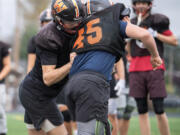 Washougal senior Elijah Franco, left, participates in a drill Tuesday, Nov. 5, 2024, at Washougal High School. The defensive standout started helping his team&Ccedil;&fnof;&Ugrave;s offense midway through the season when he began taking snaps at quarterback and running back.