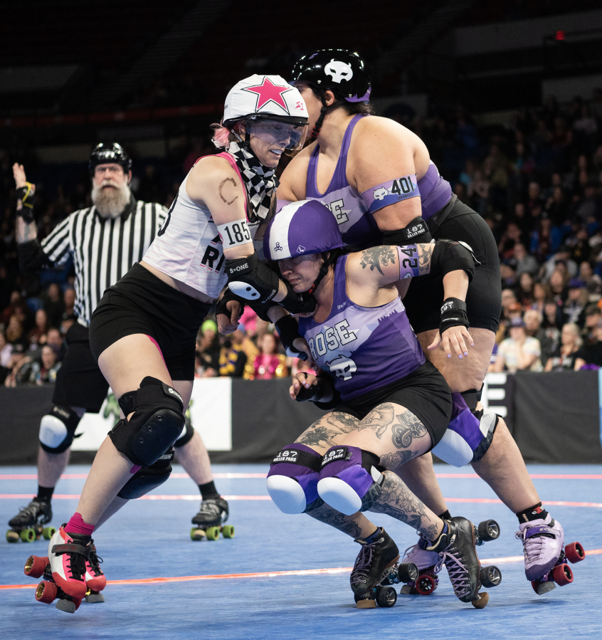 Rose City Rollers&rsquo; Mia Palau (247) falls between teammate Tarantula (401) and Arch Rival jammer Vicious Van GoGo (1543) on Sunday during the Women&rsquo;s Flat Track Derby Association Global Championships at Veterans Memorial Coliseum in Portland. Rose City Rollers&rsquo; all-star team, Wheels of Justice, won its fifth overall title 141-104 against Arch Rival All Stars from St. Louis, Mo.