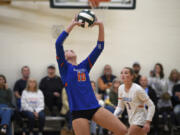 Ridgefield senior Callie Curran sets the ball ahead of Tava Whitlow (3) during a first-round match against R.A. Long at the Class 2A District 4 volleyball tournament on Thursday, Nov. 7, 2024 at Woodland High School.