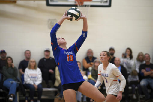 Ridgefield senior Callie Curran sets the ball ahead of Tava Whitlow (3) during a first-round match against R.A. Long at the Class 2A District 4 volleyball tournament on Thursday, Nov. 7, 2024 at Woodland High School.