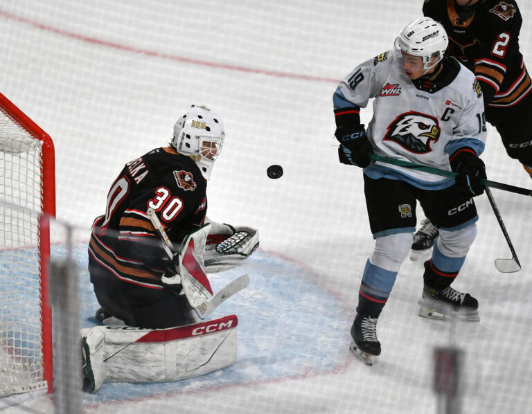 Portland forward Kyle Chyzowski (19) and Calgary goalie Kason Kobelka (30) watch a puck fall through the air Wednesday, Nov. 13, 2024, during the Winterhawks’ 3-1 loss to the Calgary Hitmen at Veterans Memorial Coliseum in Portland.