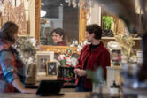 Sales associate Olivia Ovall, in red, is reflected in a mirror as she checks out some of the items for sale as Not Too Shabby in Vancouver gears up for the holidays. Clark County retailers hired about 450 people between October and December last year, according to data from the Washington Employment Security Department.