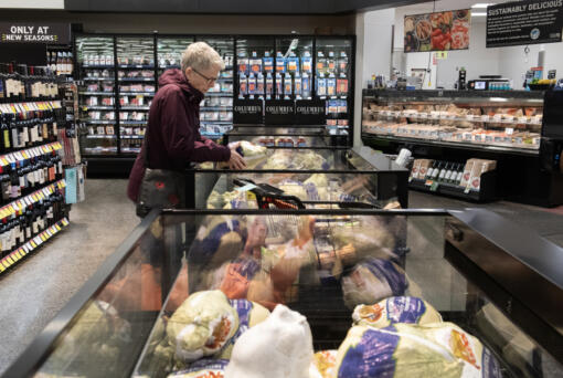 Karen Goritski of Camas selects a turkey while joining shoppers at the Fisher&rsquo;s Landing New Seasons Market the week before Thanksgiving. The day before Thanksgiving is the single busiest food shopping day nationwide.