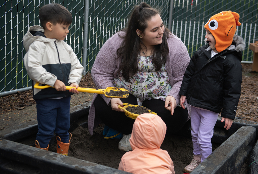 St. Johns Early Learning Center student Kani Dando, 4, from left, plays in a sandbox Monday with teacher-in-training Tia Thomas and student Daria Shenderovska, also 4. Thomas went through Educational Opportunities for Children and Families&rsquo; Parent University to work in early education.