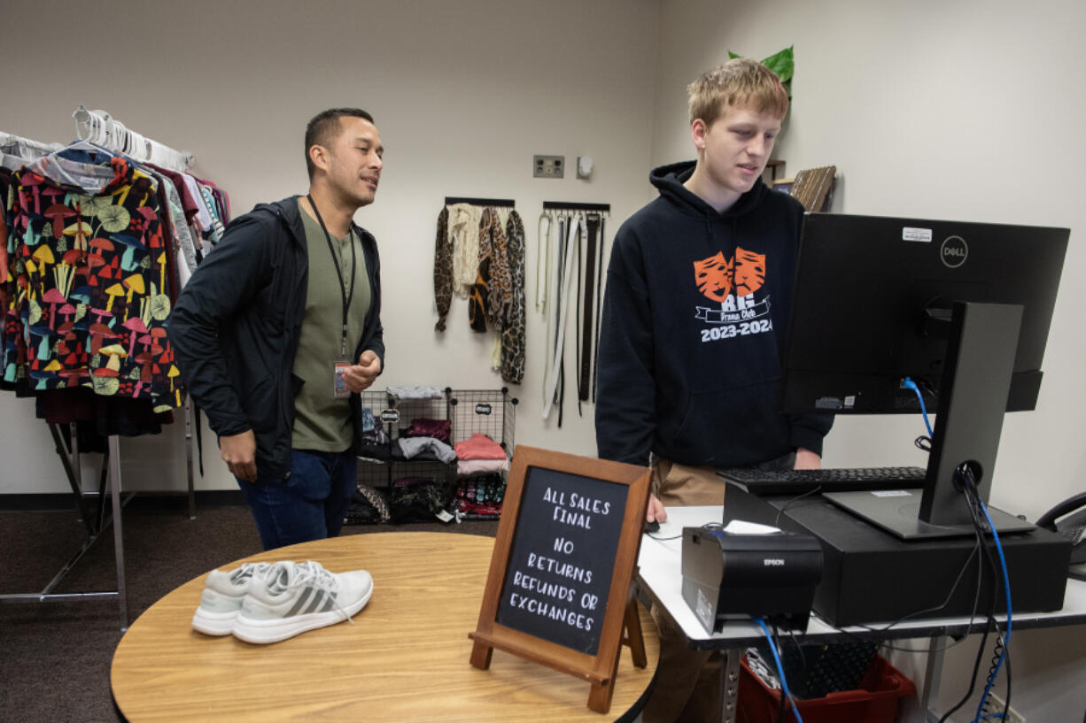 Counselor Nick Santilli, left, works with senior Zac French, 17, at the BG Thrift Store on Wednesday at Battle Ground High School.